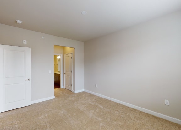 Bedroom with carpet; door to bathroom