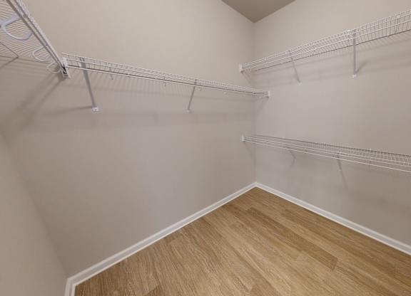 a large walk-in closet with racks and shelves