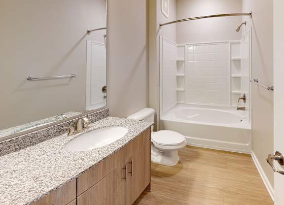 a bathroom with granite countertops and luxury vinyl plank flooring