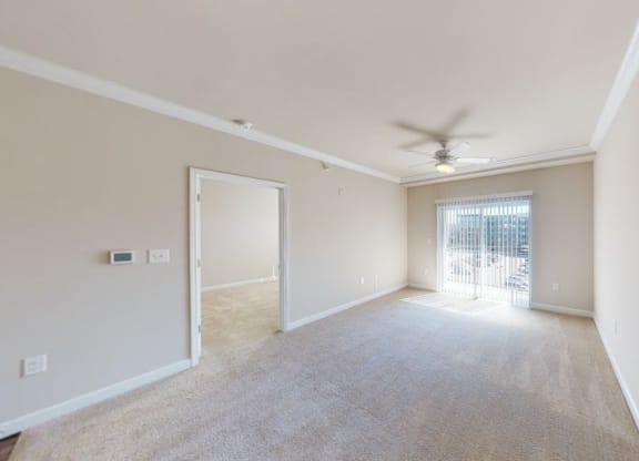 Living room with carpet; ceiling fan; door to patio