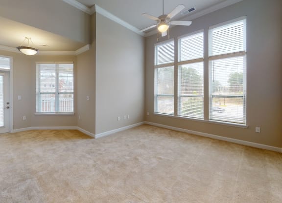 Living room with ceiling fan, high ceilings and door to balcony