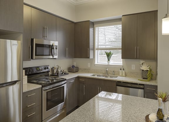 Kitchen with island, dark cabinets, vinyl floors and granite countertops