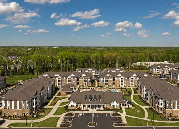 A large apartment complex with a green lawn in front.