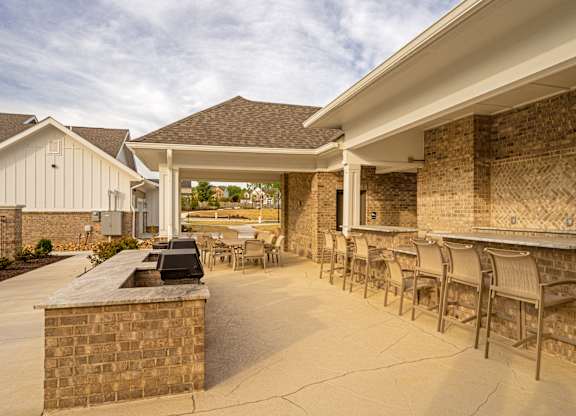 A patio area with a bar and chairs.