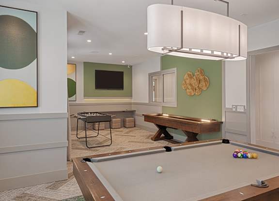 A billiard table is set up in a room with a pool table light.