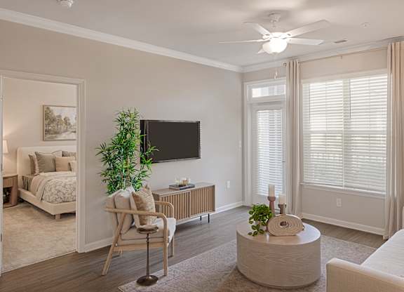 A living room with a chair, a table, and a television.