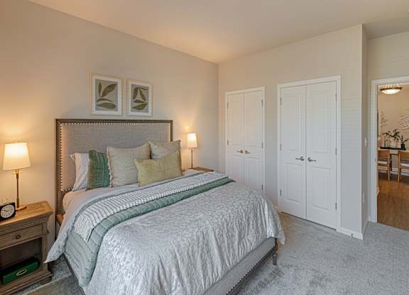 A bedroom with a large bed and a mirror on the wall.