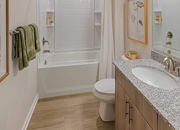 A white bathroom with a toilet, sink, and bathtub.