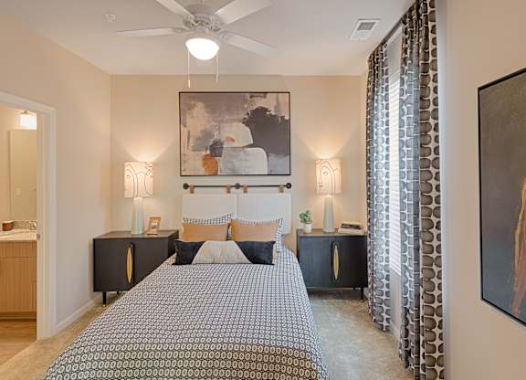 A bedroom with a large bed and a painting on the wall.