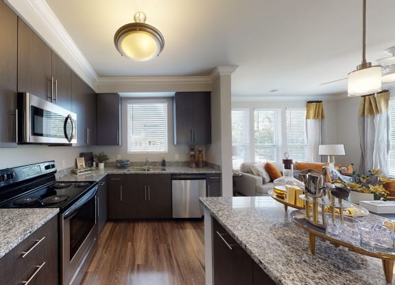 Kitchen with island, dark cabinets, vinyl floors and granite countertops