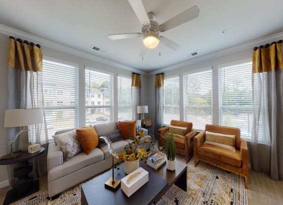 Living room with windows, ceiling fan, carpet
