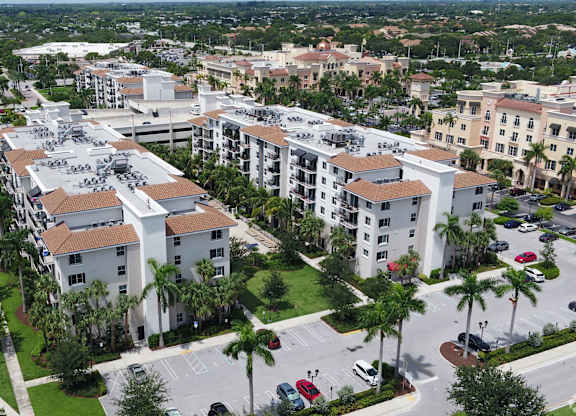 A large apartment complex surrounded by palm trees.