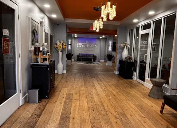 A long hallway with a wooden floor and a sofa.