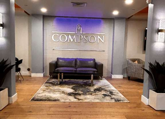 A Compson logo is displayed on a wall above a couch.