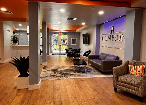 A lobby with a leather couch and a sign reading “Compson”.