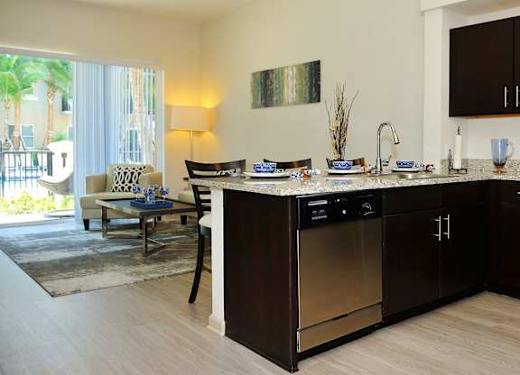 A modern kitchen with dark brown cabinets and stainless steel appliances.