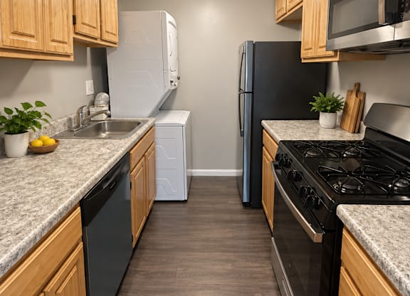 A kitchen with black appliances and wooden cabinets.