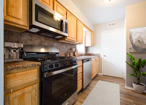 A kitchen with wooden cabinets and a black stove top oven.