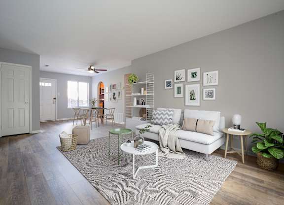 A living room with a white couch, a green chair, and a rug.