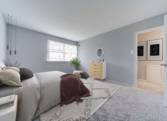 A bedroom with a bed, a dresser, and a window.