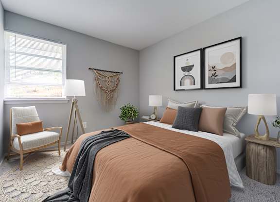 A bedroom with a large bed and a chair by the window.