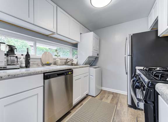 A kitchen with white cabinets and stainless steel appliances.