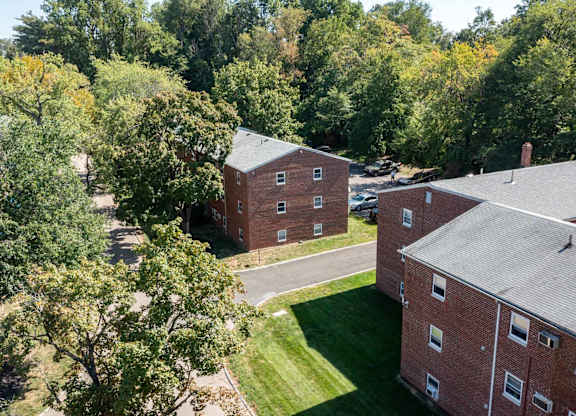 A view of a courtyard surrounded by trees and buildings.at Grant Meadows Apartments, Philadelphia, 19114