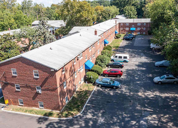 A parking lot with cars and a building in the background.at Grant Meadows Apartments, Philadelphia Pennsylvania