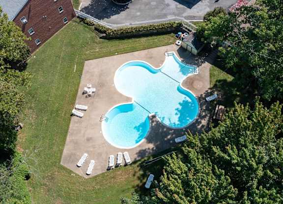 A large swimming pool surrounded by trees and a building.at Grant Meadows Apartments, Philadelphia