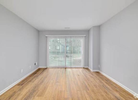 A room with wooden flooring and a window with blinds at Brookshire Trace Townhomes Apartments, Philadelphia, 19116