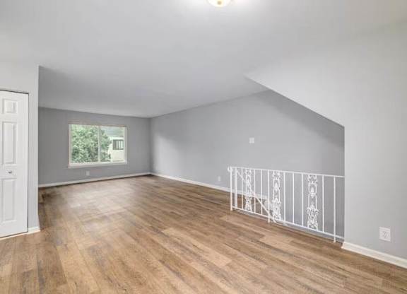A room with wooden flooring and white railings at Brookshire Trace Townhomes Apartments, Philadelphia, PA