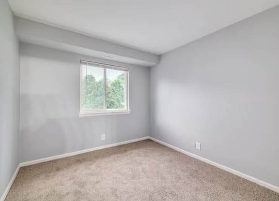 A room with a window and carpeted floor at Brookshire Trace Townhomes Apartments, Philadelphia
