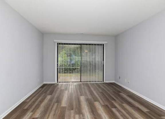 A room with wooden flooring and a sliding glass door at Brookshire Trace Townhomes Apartments, Philadelphia, PA, 19116