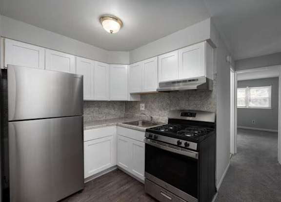 A kitchen with white cabinets and a stainless steel refrigerator.at Grant Meadows Apartments, Philadelphia, PA 19114