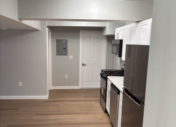 A kitchen with white cabinets and stainless steel appliances.at Lawndale Apartments, Philadelphia, PA