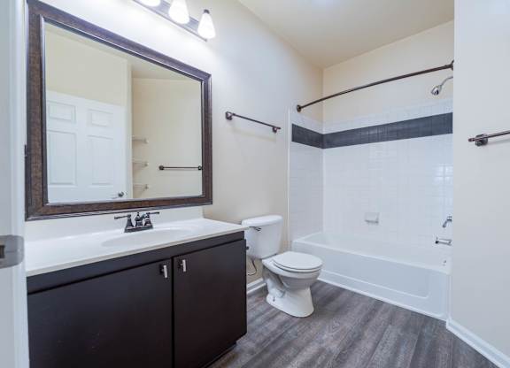 A bathroom with a white toilet and a white bathtub.
