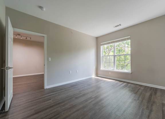 A room with a wooden floor and a window.