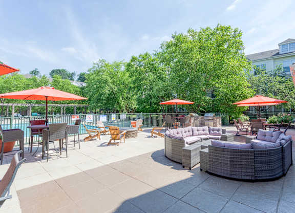 A patio with a table and chairs and umbrellas.