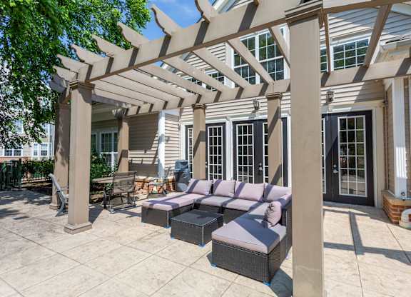 A patio with a couch and a pergola.