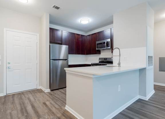 A kitchen with a white counter and a stainless steel refrigerator.