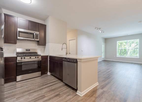 A kitchen with dark brown cabinets and stainless steel appliances.