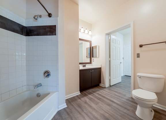 A white toilet sits next to a bathtub in a bathroom.