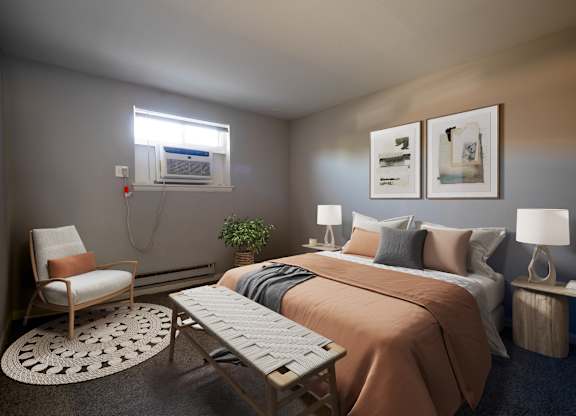 A bedroom with a bed, chair, and two lamps.