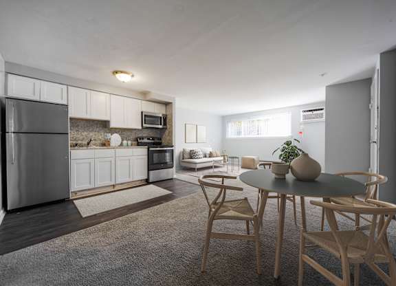 A modern kitchen with a dining table set for two.