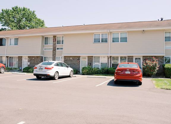 a parking lot with cars in front of a building at Franklin Square Townhomes, Philadelphia, PA