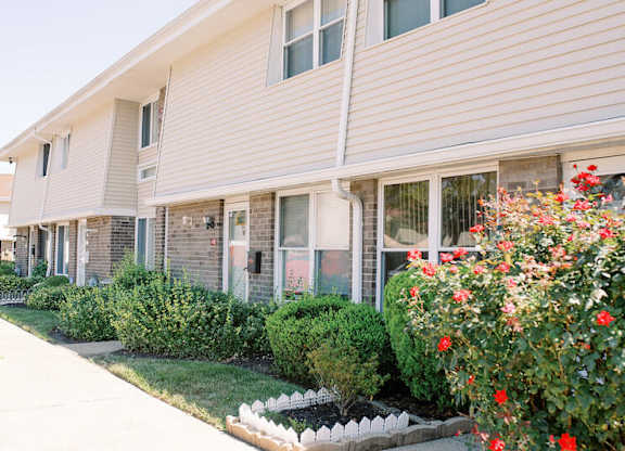 a building with flowers and bushes in front of it at Franklin Square Townhomes, Philadelphia