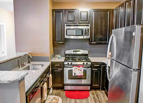 a kitchen with stainless steel appliances and wooden cabinets at Riverview Landing @ Valley Forge, Eagleville, PA