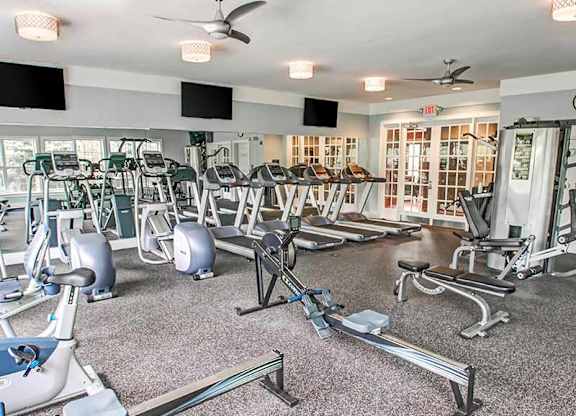 a gym with cardio machines and weights in a room with windows at Riverview Landing @ Valley Forge, Eagleville, PA