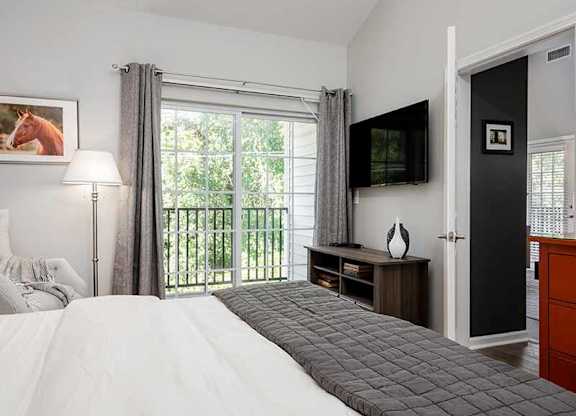 a bedroom with a bed and a tv and a balcony at Riverview Landing @ Valley Forge, Eagleville, 19403