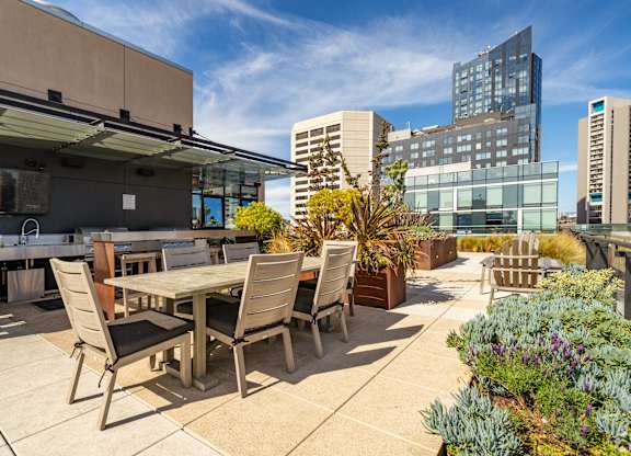 A patio with a table and chairs overlooks a cityscape.